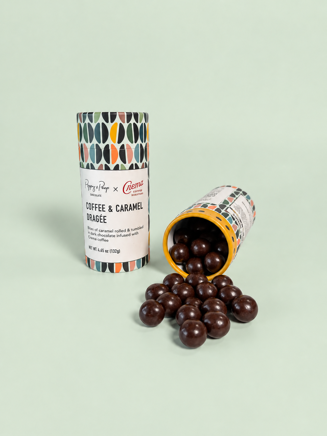 Two Coffee & Caramel Dragée tubes, one tipped over with dark chocolate covered coffee caramels spilling out
